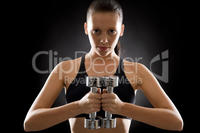 Young woman exercise weights black background