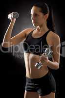Young fit woman exercise weights on black