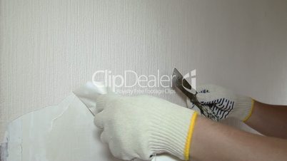 Man removing old wallpaper with the tool