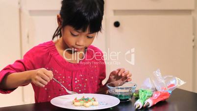 Excited Girl Adds Finishing Touch To Christmas Cookie