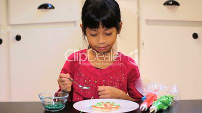 Girl Adds Sprinkles To Her Christmas Cookie