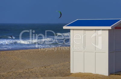 Holzhütte in weiß am Strand mit Kitesurfer