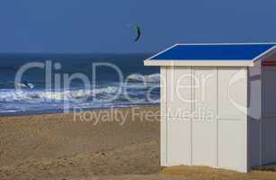 Holzhütte in weiß am Strand mit Kitesurfer