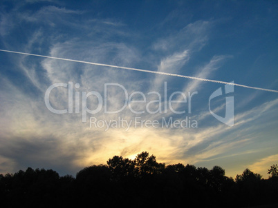 Evening landscape with clouds and trace of plane