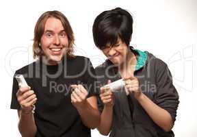 Mixed Race Couple Playing Video Game Remotes on White