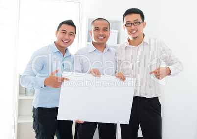 Asian business team holding a blank banner