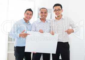 Asian business team holding a blank banner