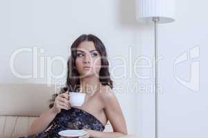 Brunette woman drinking coffee in living room
