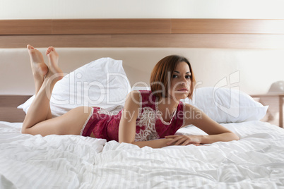 Woman in lingerie lying on bed