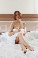 Woman in bedroom with cup of coffee