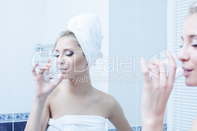 Woman with glass of water in bathroom