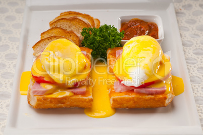 eggs benedict on bread with tomato and ham