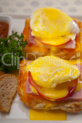 eggs benedict on bread with tomato and ham