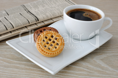 a cup of coffee and biscuits and a newspaper