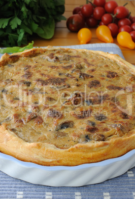 tart with mushrooms in a ceramic form on a napkin