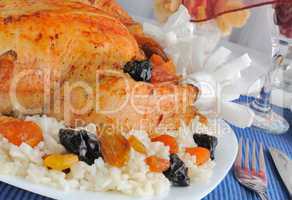a fragment of grilled chicken with rice and dried fruit