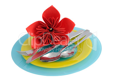 a set of cutlery on a plate with a flower made ??of paper na
