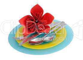 a set of cutlery on a plate with a flower made ??of paper na