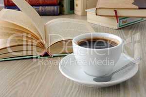 cup of coffee on a table with books.