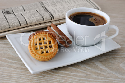 a cup of coffee and biscuits and a newspaper