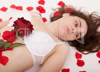 Ein junge Frau von Rosenblättern umgeben