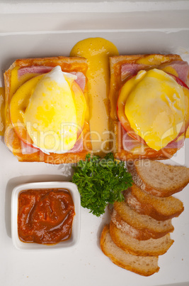 eggs benedict on bread with tomato and ham