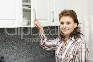 Woman opens a cupboard