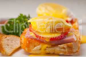 eggs benedict on bread with tomato and ham