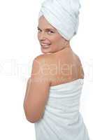 Hot woman in bath towel turning back towards camera