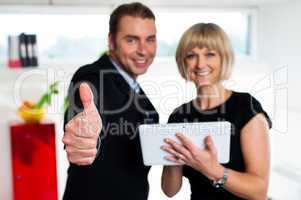 Secretary with a tablet posing with her successful boss