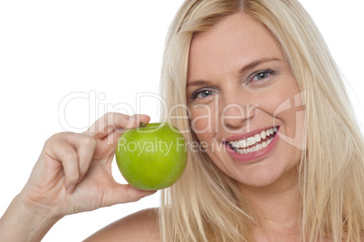 Closeup shot of a cheerful woman holding an apple