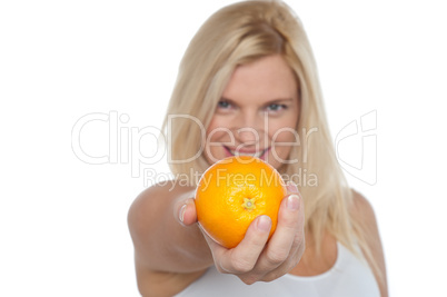 Gorgeous woman with an orange in her outstretch arm