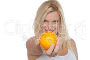 Gorgeous woman with an orange in her outstretch arm