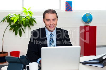 Corporate leader sitting in front of his laptop