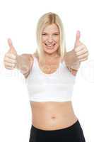Fit woman in sports bra gesturing double thumbs up