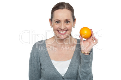 Portrait of a woman holding up an orange