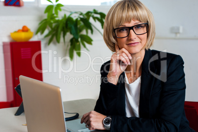 Thoughtful business lady seated in office