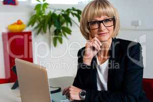 Thoughtful business lady seated in office