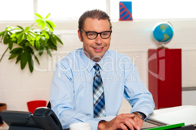 Bespectacled senior manager working in his office