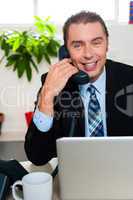 Smiling male manager attending clients call