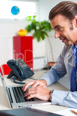 Businessman typing report on a laptop