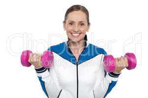 Happy woman carrying dumbbells in both hands