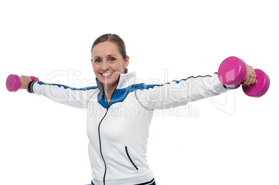 Woman holding dumbbells in her outstretched arms