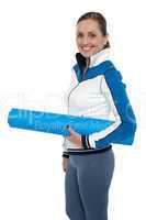 Woman carrying blue yoga mat