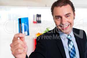 Handsome male executive holding cash card