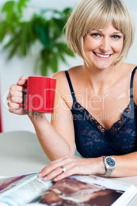 Relaxed woman in lingerie enjoying her beverage