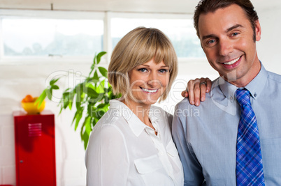 Cheerful business couple in their new office