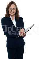 Corporate woman in eyeglasses writing on clipboard