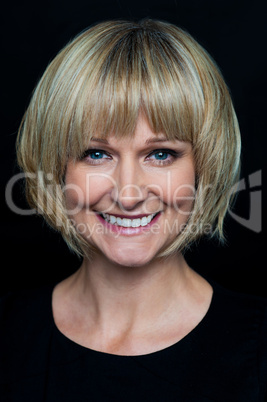 Cheerful blonde woman on black background