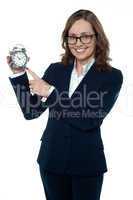 Corporate executive pointing towards the clock